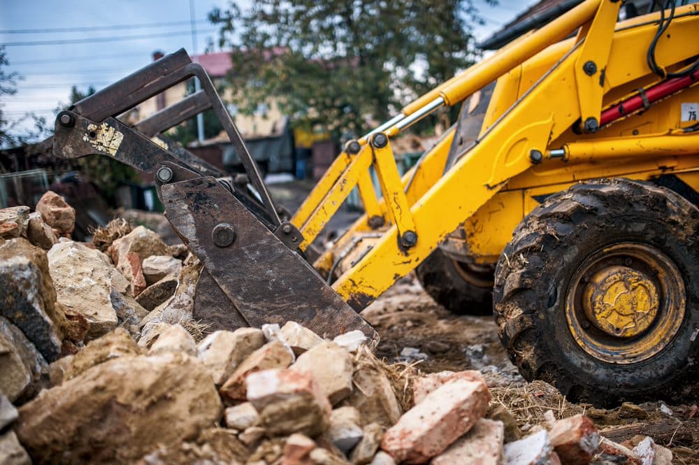 Yellow bulldozer demolishing house — Demolishing & Remediation In Heatherbrae, NSW