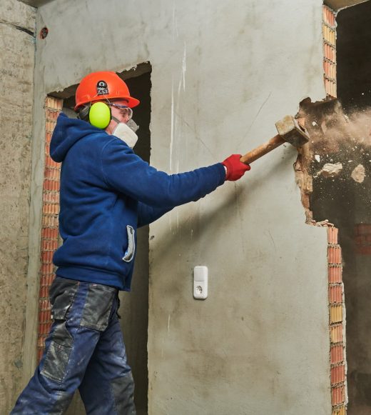 Worker demolishing a wall — Demolishing & Remediation In Heatherbrae, NSW